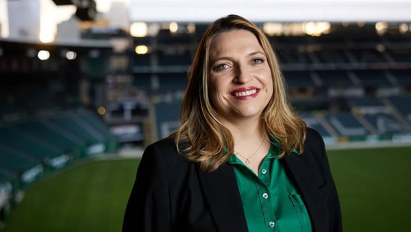 Headshot of Heather Davis in front of a soccer stadium.
