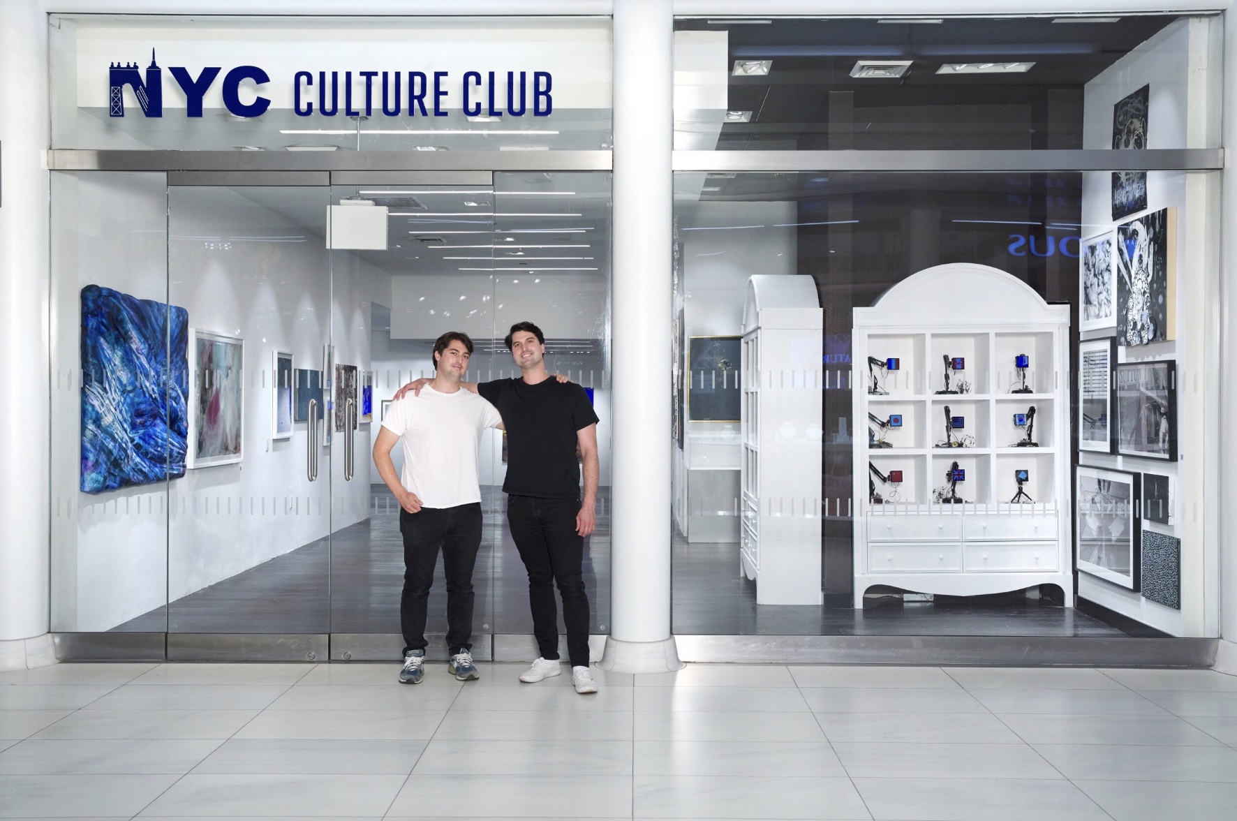 Clayton and Parker Calvert stand in front of a building named "NYC Culture Club."C Culture