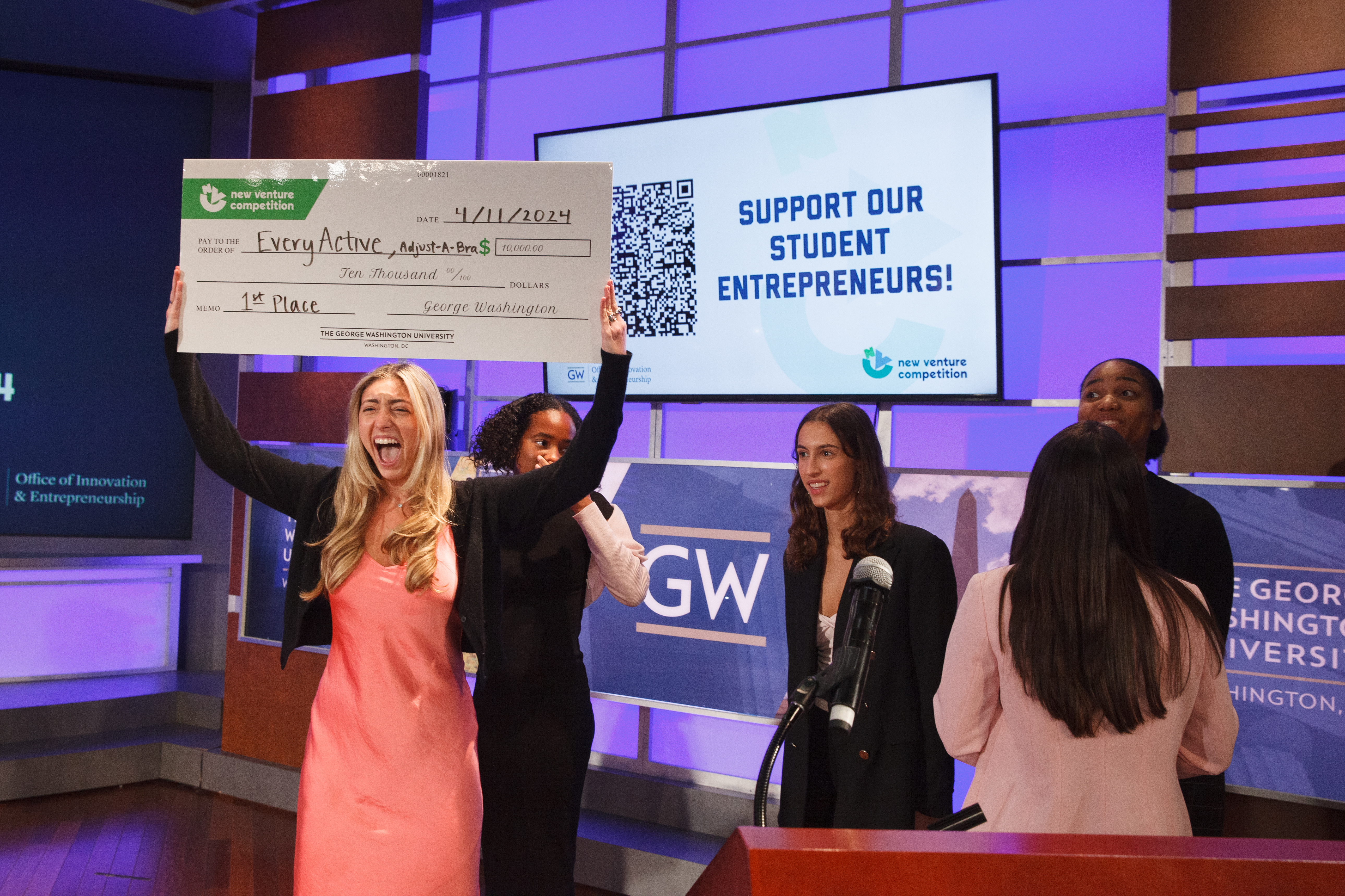 GW Business junior Camryn Baum celebrates with a first-place check after she and her team won the Consumer Goods and Services Track at Thursday's 16th annual New Venture Competition. (Photos by Rick Reinhard/For GW Today)