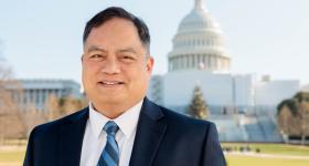 Capitol Police Officer Alan Orquiza stands in front of The United States Capitol Building.