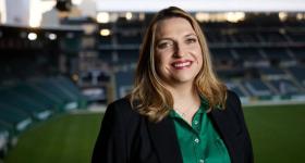 Headshot of Heather Davis in front of a soccer stadium.