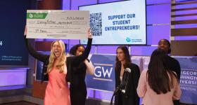 GW Business junior Camryn Baum celebrates with a first-place check after she and her team won the Consumer Goods and Services Track at Thursday's 16th annual New Venture Competition. (Photos by Rick Reinhard/For GW Today)
