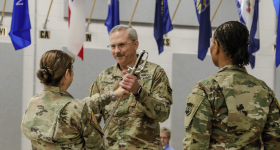 Dan Fuhrman, MIPP ’15 presenting a sword in ceremony with two individuals.
